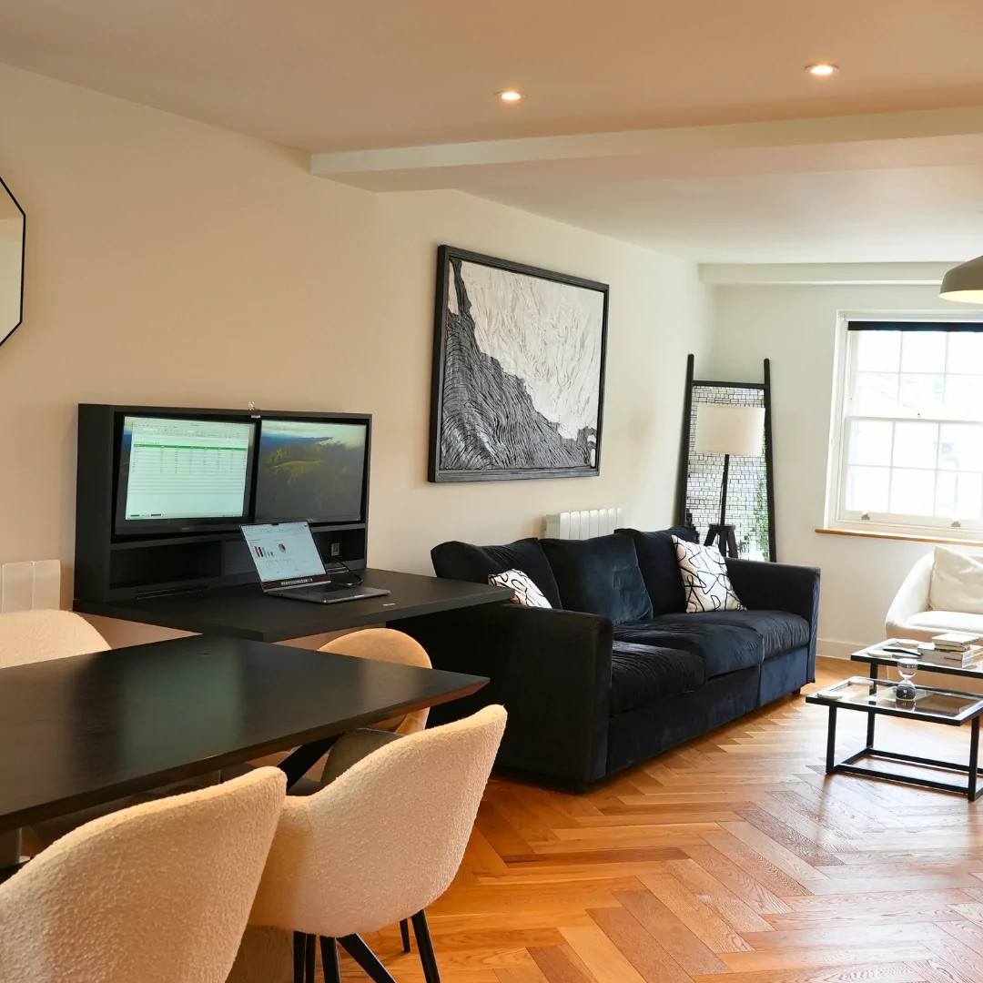 Open DropTop Duo desk with dual monitors set up in a living room workspace.