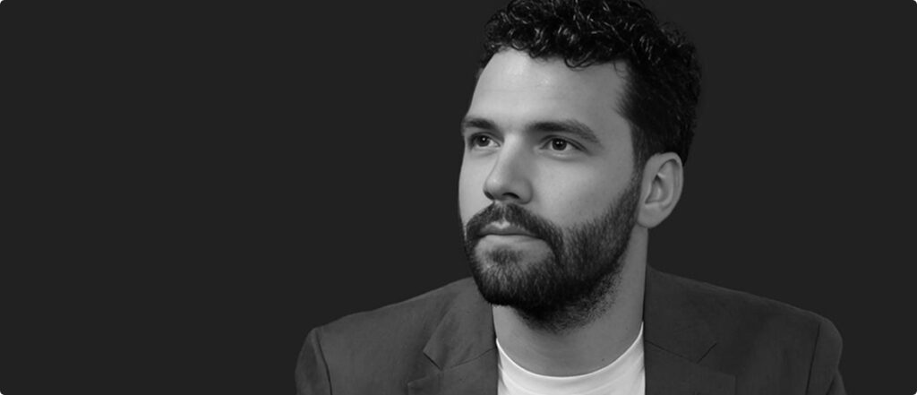 Portrait of Stefan looking to the side against a dark background.