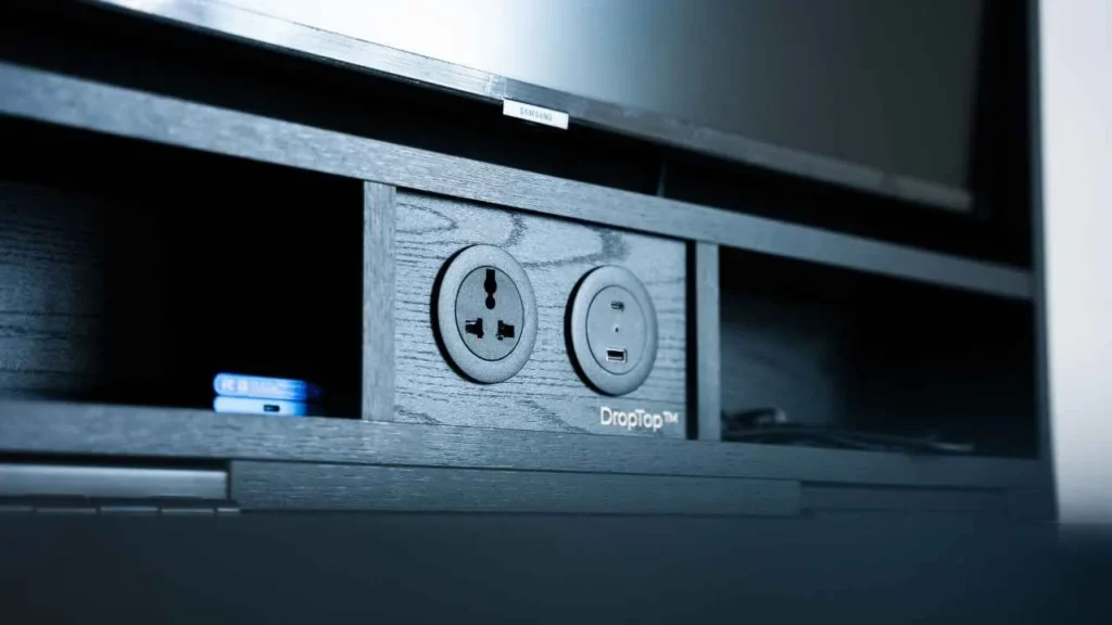 Wall desk storage section featuring built in electrical outlets and charging ports for workspace convenience.