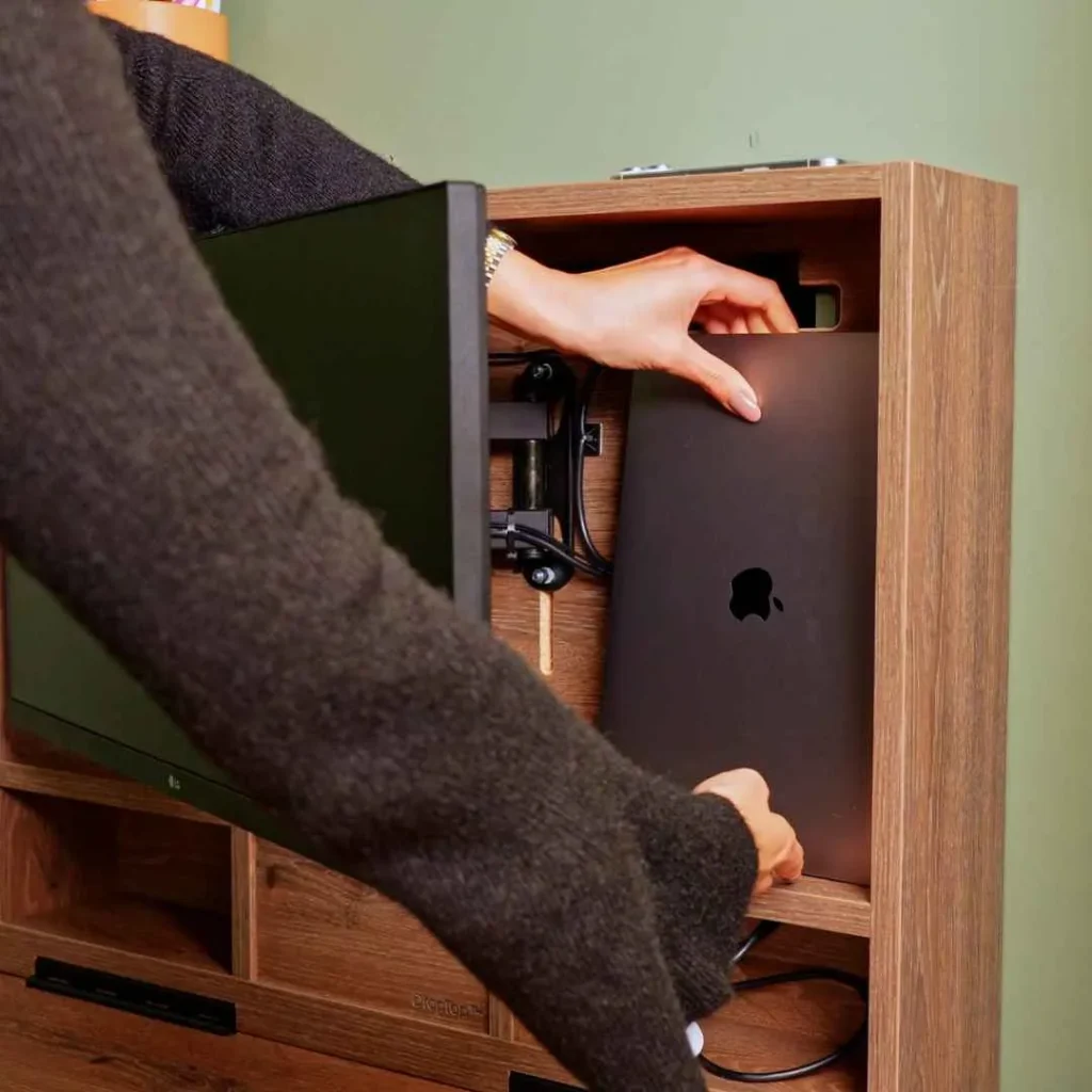 Person placing a laptop inside an open DropTop desk.