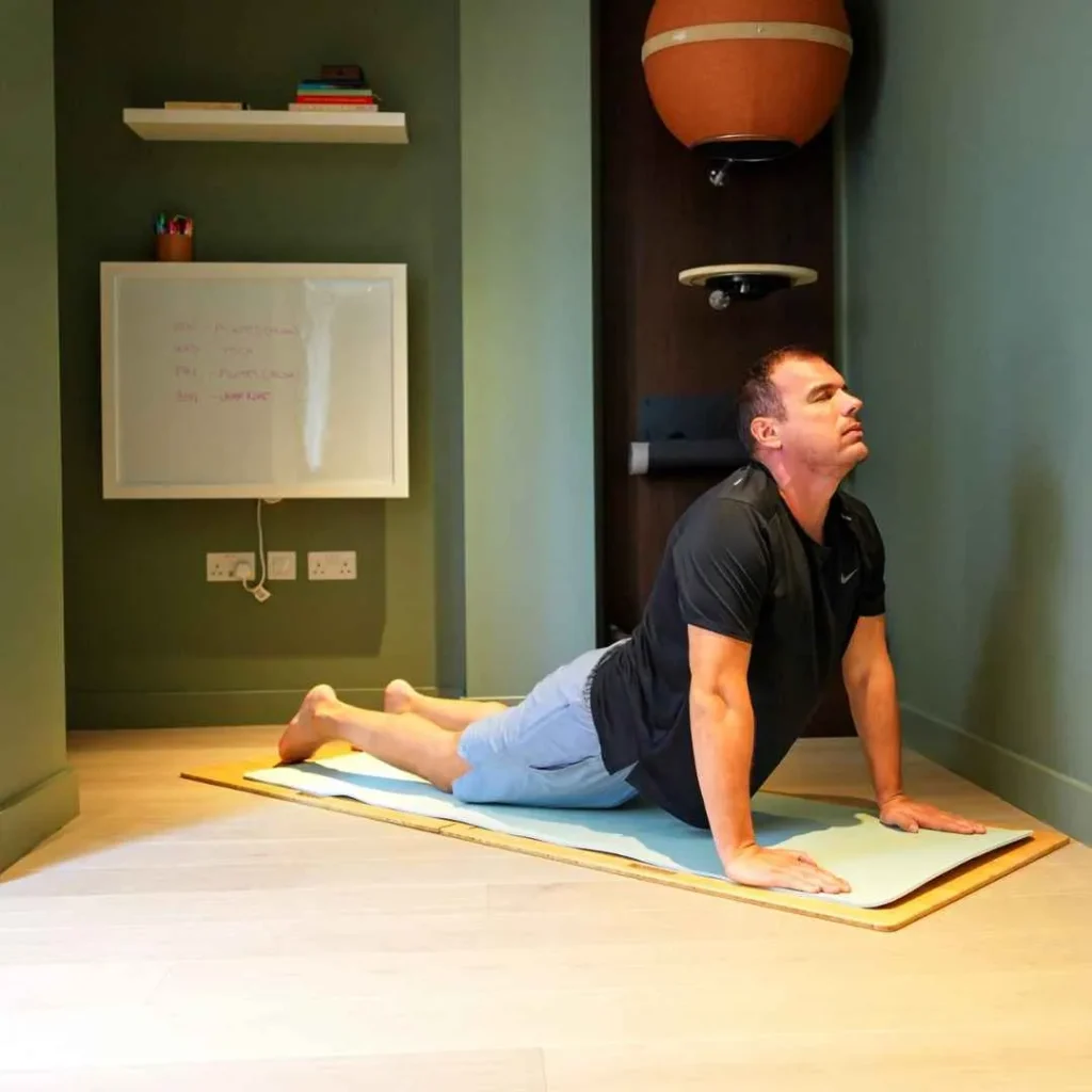 Person stretching on a mat in a home space with the DropTop desk closed.