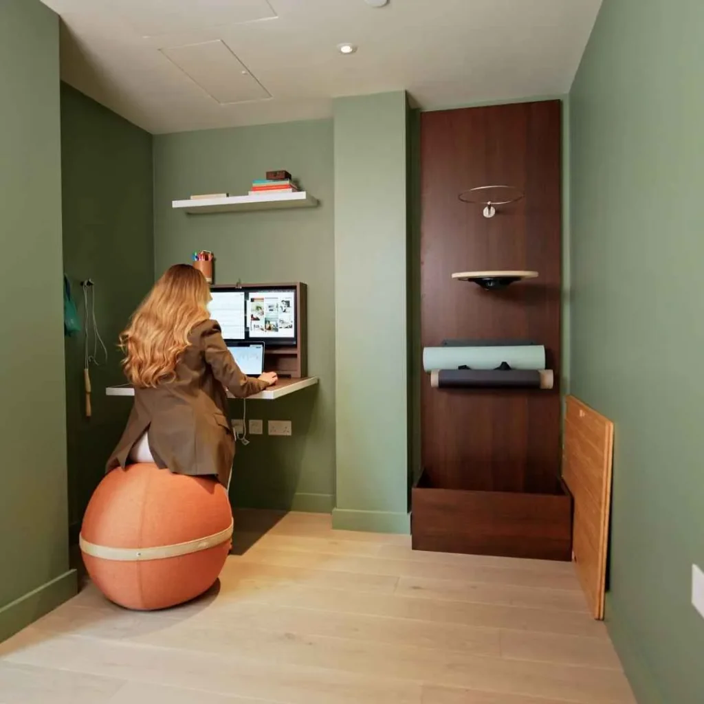 Person working at an open DropTop desk with monitor setup.