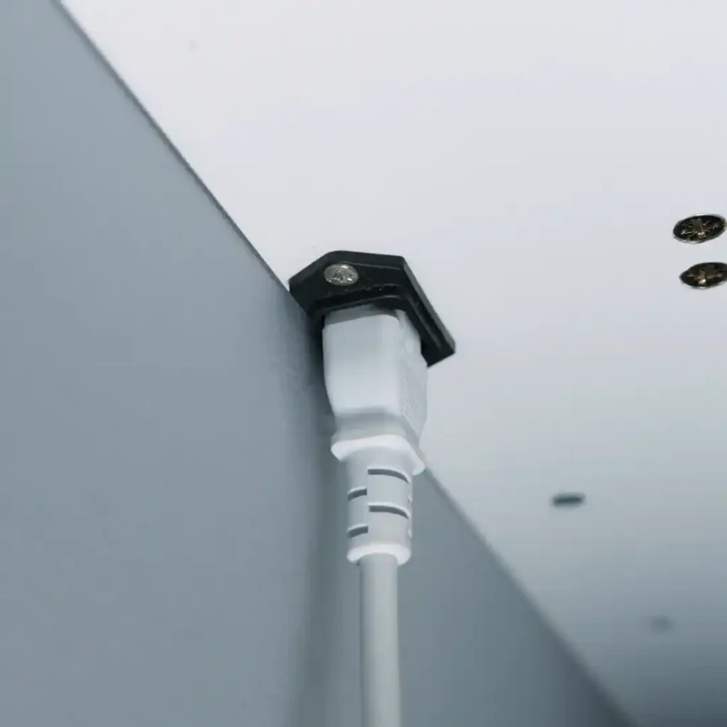 Close up of power cord neatly secured in integrated cable channel on floating desk