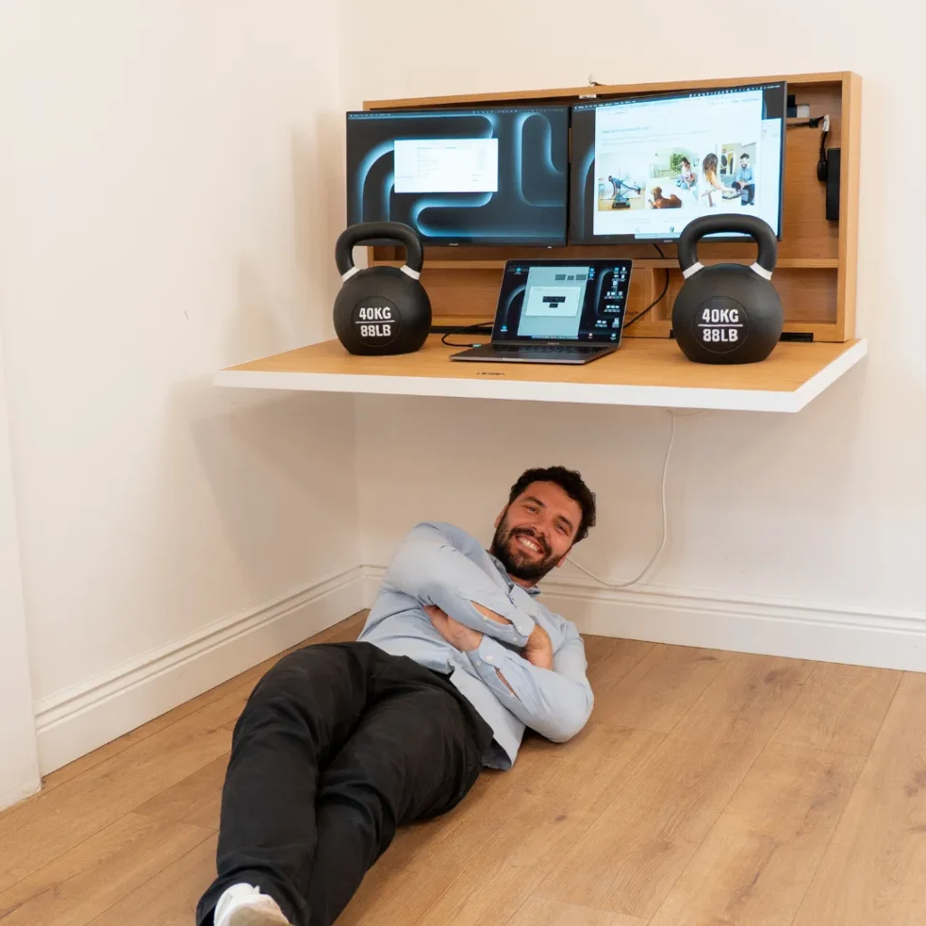 Floating wall workstation holding weights, screens and laptop demonstrating durable load capacity.
