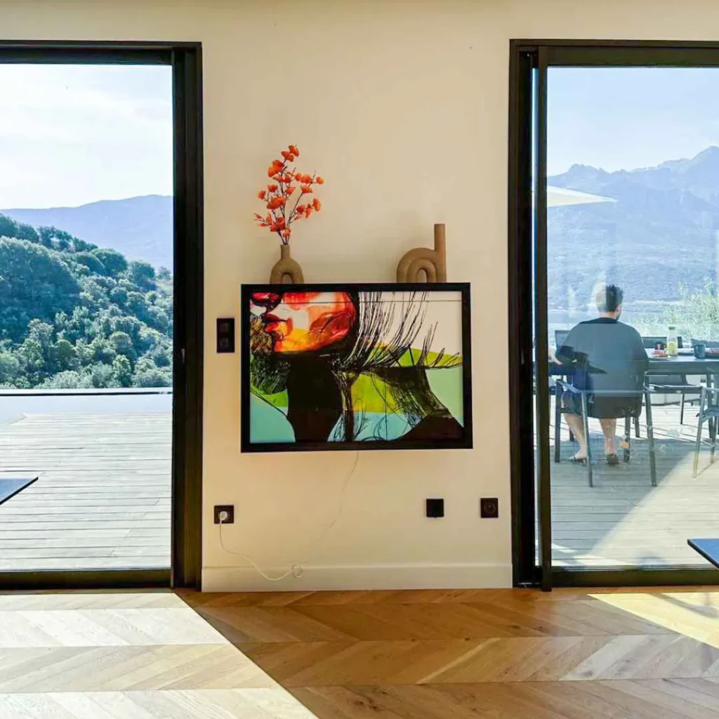 Closed wall-mounted DropTop desk designed to look like wall art between two glass doors.