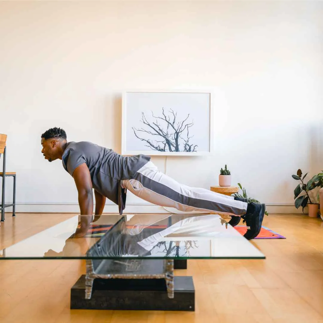 Wall-Mounted Folding Desks for Home Offices A fit man doing pushups on an exercise mat in front of his closed DropTop desk.