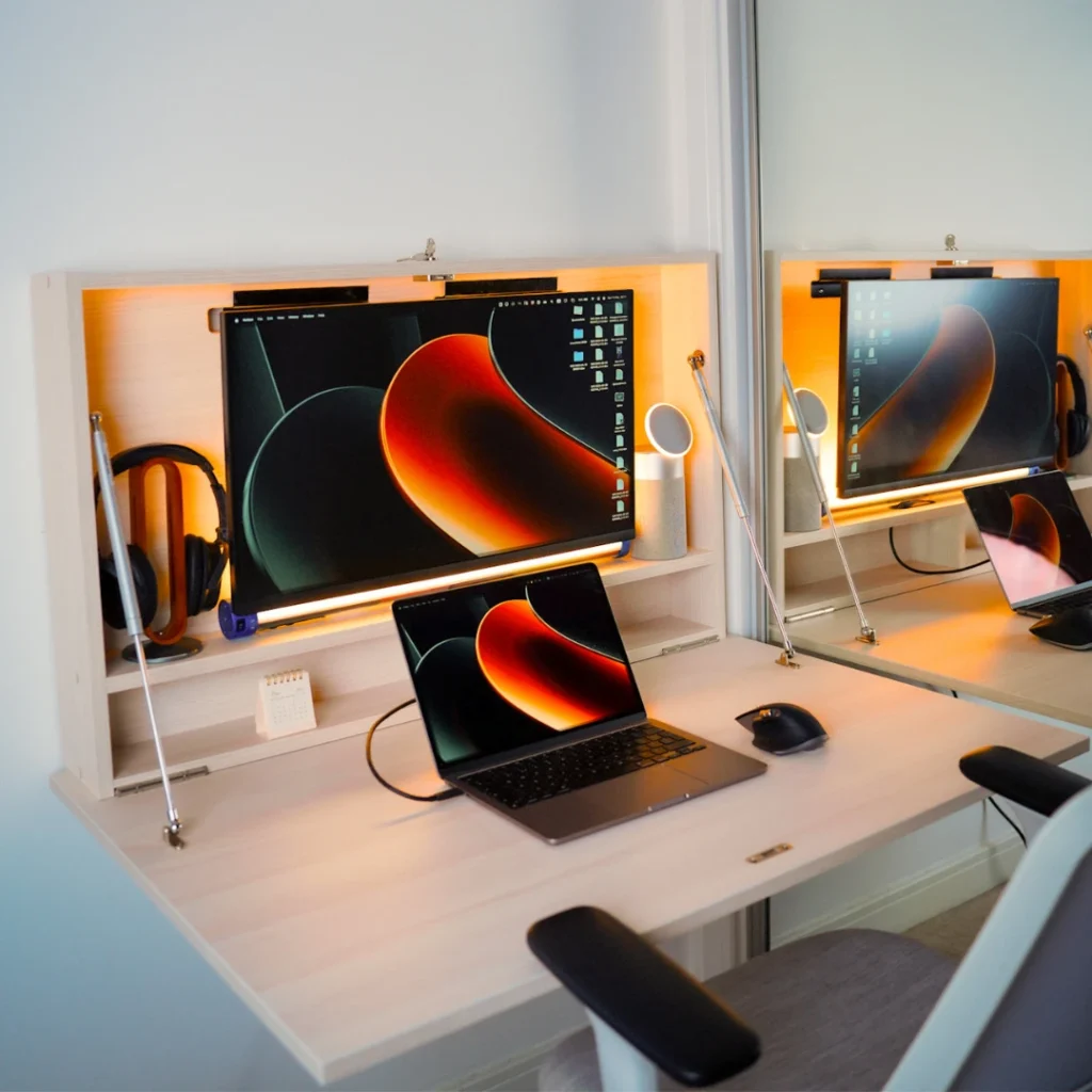 DropTop desk with integrated lighting, monitor and laptop creating a modern small space workstation