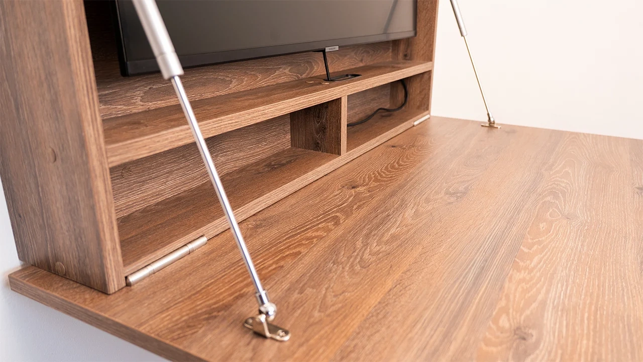 DropTop wall desk interior storage and support mechanism on wooden folding floating desk setup.