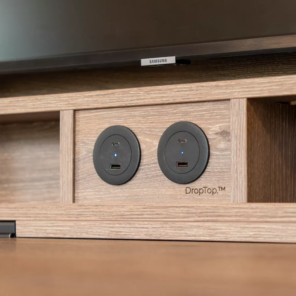 Integrated USB power sockets built into DropTop desk shelving in wood finish.