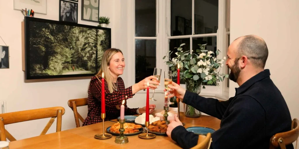 Couple having dinner in a room with a closed DropTop desk on the wall.