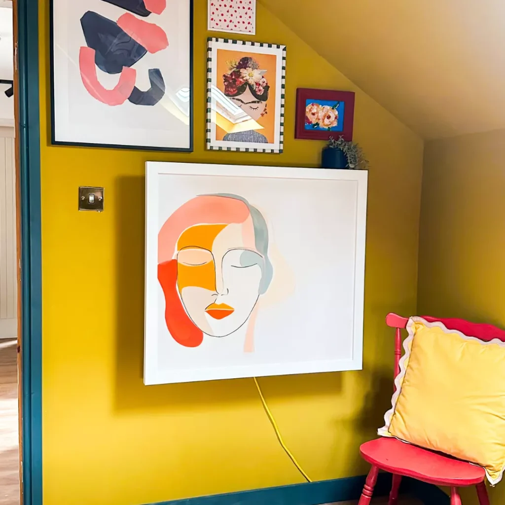 DropTop desk closed, styled as wall art above a red chair.